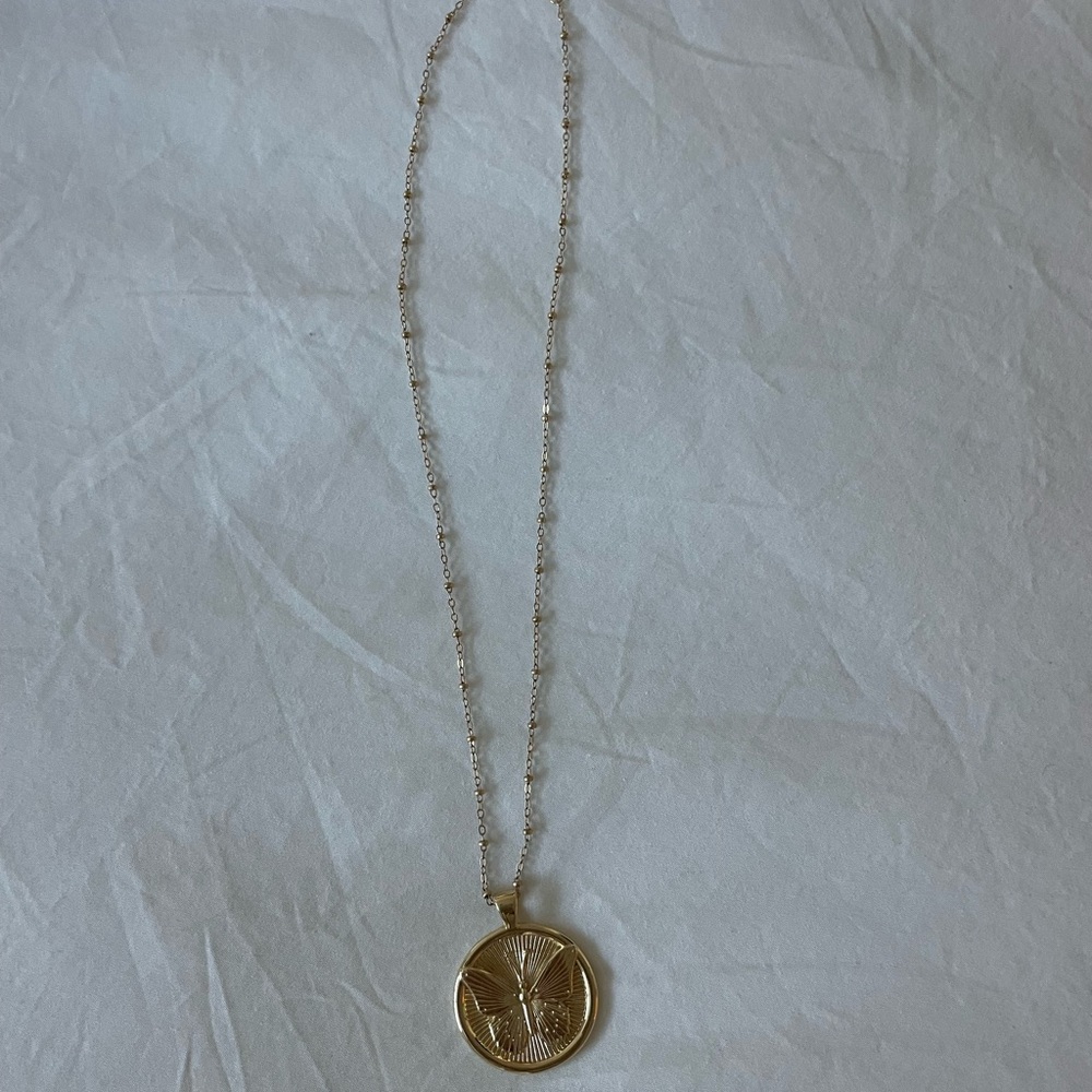Jane Win hold Butterfly “Free” Pendant with chain.